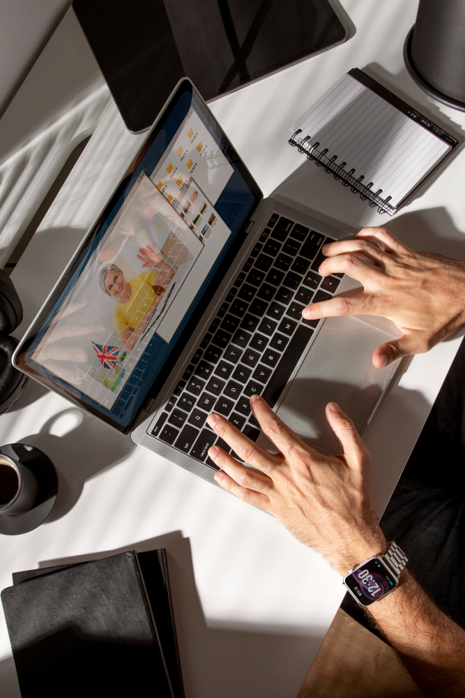 Visão de cima das mãos de uma pessoa usando um laptop